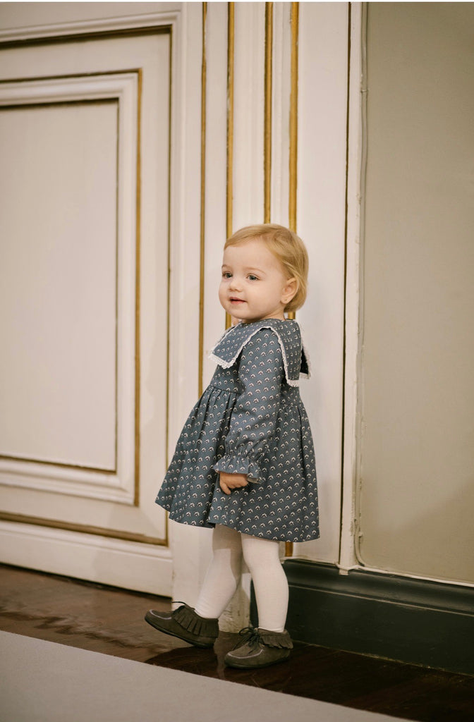 Upscale Baby dressed in adorable clothing brand dress
